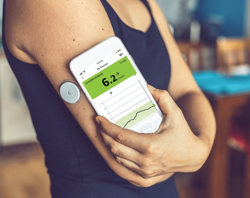 Vrouw met continue glucose sensor, als ondersteuning bij hormonale gezondheid